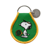 Snoopy tennis patch keychain on a green teardrop patch with yellow border and a metal key ring