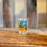 Colorful desert themed shot glass featuring cacti and the Dry Heat Arizona branding.