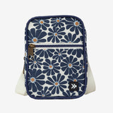 Small crossbody bag with navy floral print and front zipper pocket.
