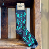 Dark navy men's Arizona Green Cactus Socks with turquoise cactus print on a wooden display.