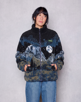 Model wearing Yosemite Night Views Full Zip fleece with mountain print in dark blue and tan with Parks Project patch