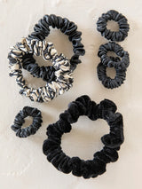 Seven piece mixed scrunchie set in black velvet and beige patterned fabrics.