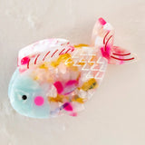 Translucent rainbow fish clip filled with multicolor confetti.