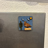 Tiny Arizona wooden magnet mounted on blue background showing desert cactus motif