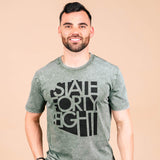 Male model wearing a moss stone State Forty Eight tee with a bold black graphic.