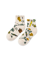 Two cream Forest Forager quarter socks in a yellow floral botanical pattern.