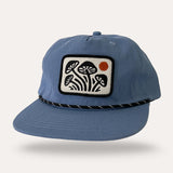 Groovy Mushrooms blue canvas flatbrim hat featuring a white patch with black mushrooms and an orange sun.