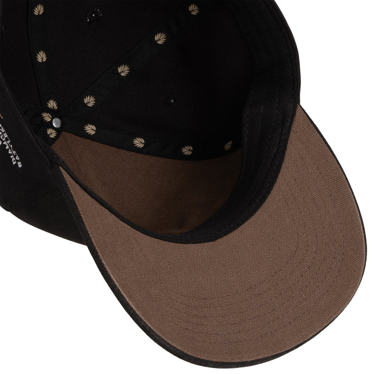 Inside back of the hat with brown interior and teal leaf logo tag on the strap