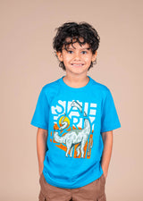 Boy wearing a bright blue State Forty Eight Kids Tee with a stylized Sonorasaurus dinosaur graphic.