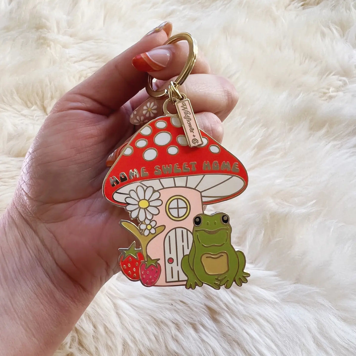 Close up of Home Sweet Home Frog Keychain with a red polka dot mushroom house a frog and flowers.