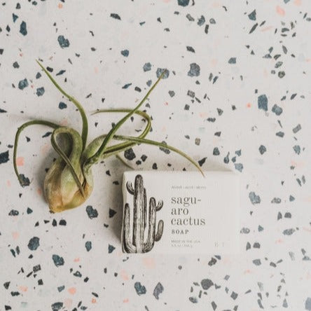 Bar of Saguaro Cactus Natural Soap on a terrazzo surface beside a card with cactus artwork.
