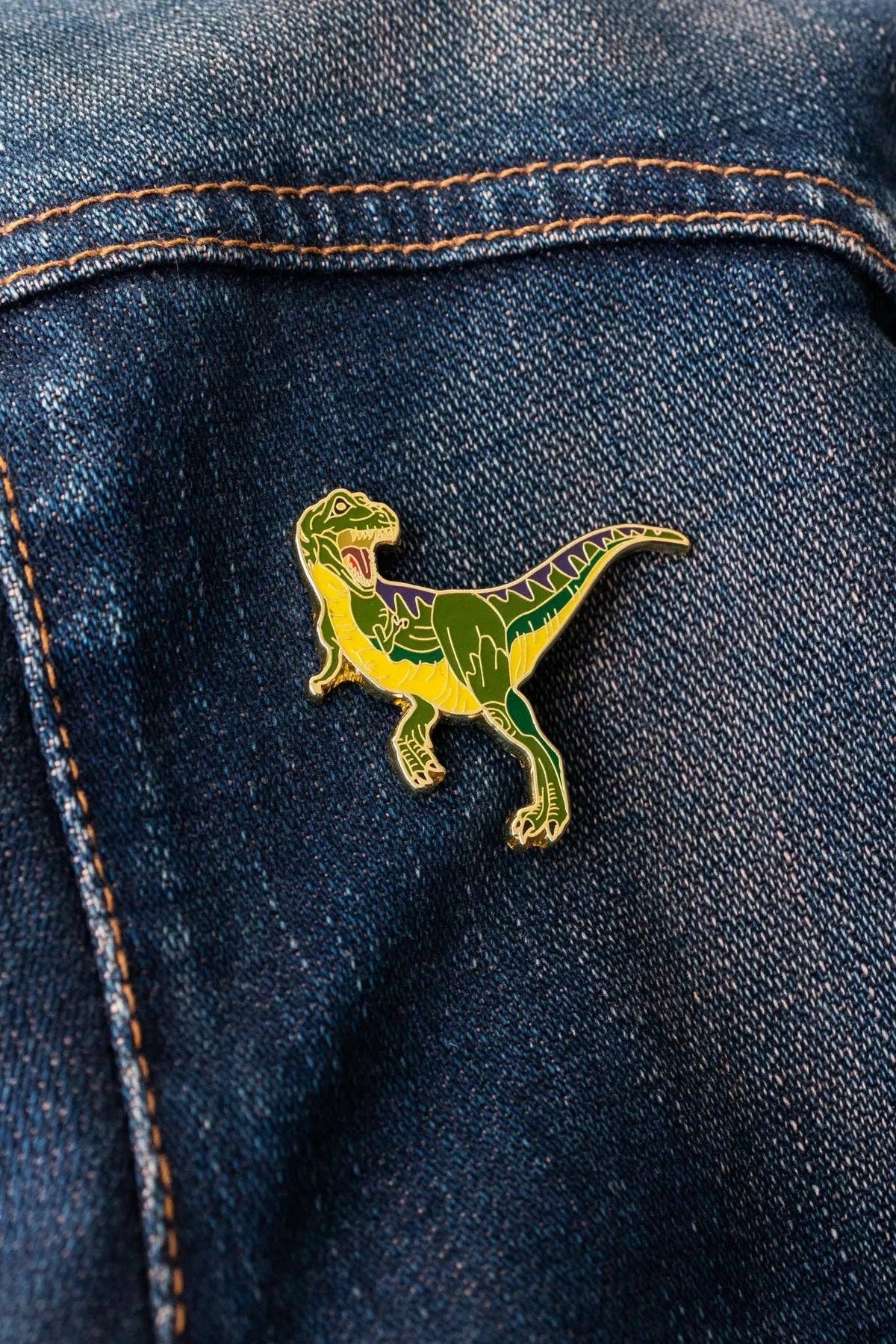 Tyrannosaurus Rex enamel pin on a blue denim jacket pocket