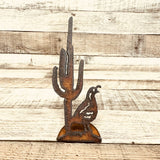 Quail and cactus desert rustic metal figurine on weathered wood surface.