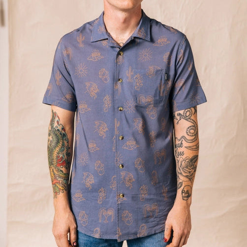 Front view of a man wearing the blue Adios Burritos Casual Button Down short-sleeve shirt with tan desert motifs.