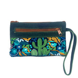 Teal suede purse wristlet with a back zip pocket and a vibrant embroidered cactus and floral panel across the bottom, with a green strap
