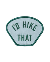 Embroidered patch with teal border on light blue fabric reading I'd Hike That