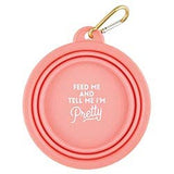 Pink collapsible silicone bowl with a gold key ring and the phrase Feed me and tell me I'm pretty.