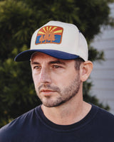 AZ Pines Two Tone Hat with white crown blue brim and an embroidered patch of pines and a rising sun