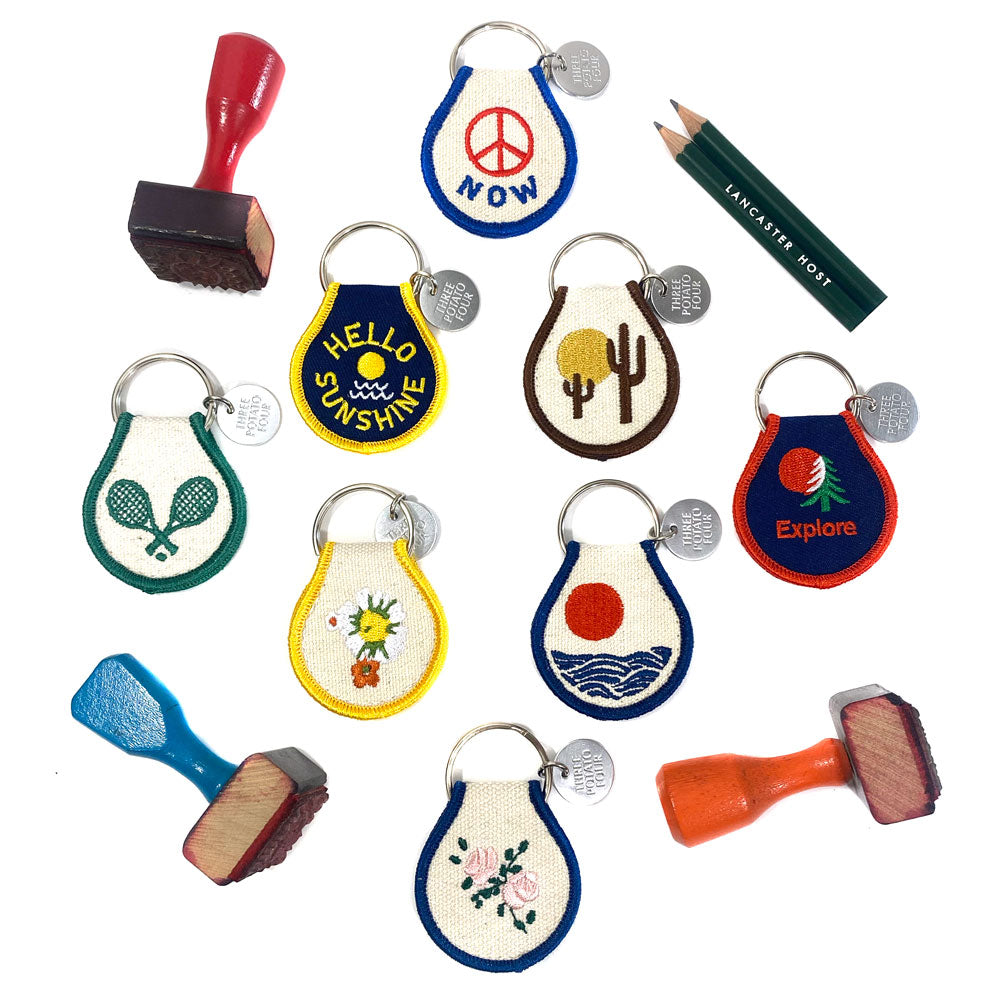 Assorted Desert Vibes patch keychains in bright colors and various desert designs for display.