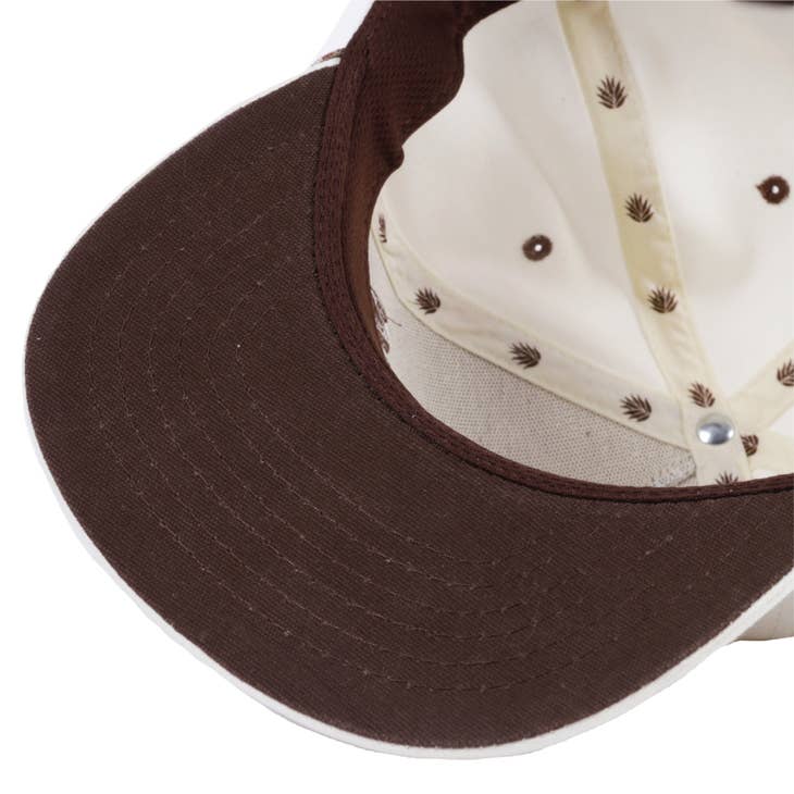Beige cap with a dark brown curved brim and palm leaf motifs along the crown