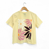 Back view of In Full Bloom Ladies Tee in Buttermilk with a large pastel floral print.