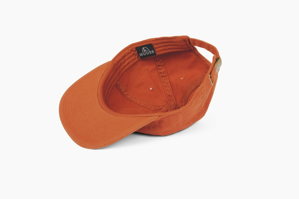 Inside view of an orange Born Traveler cap with a Moore label and an adjustable strap.