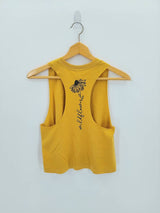 Mustard yellow Wildflower Racerback Tank back view on a wooden hanger with a vertical floral graphic.