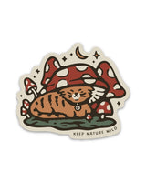 Tabby cat curled beneath oversized red and white mushrooms in a whimsical sticker