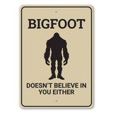 Bigfoot Doesn't Believe sign featuring a black Bigfoot silhouette on a tan plaque with bold text