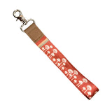 Red orange mushroom pattern wrist lanyard with a metal clasp.