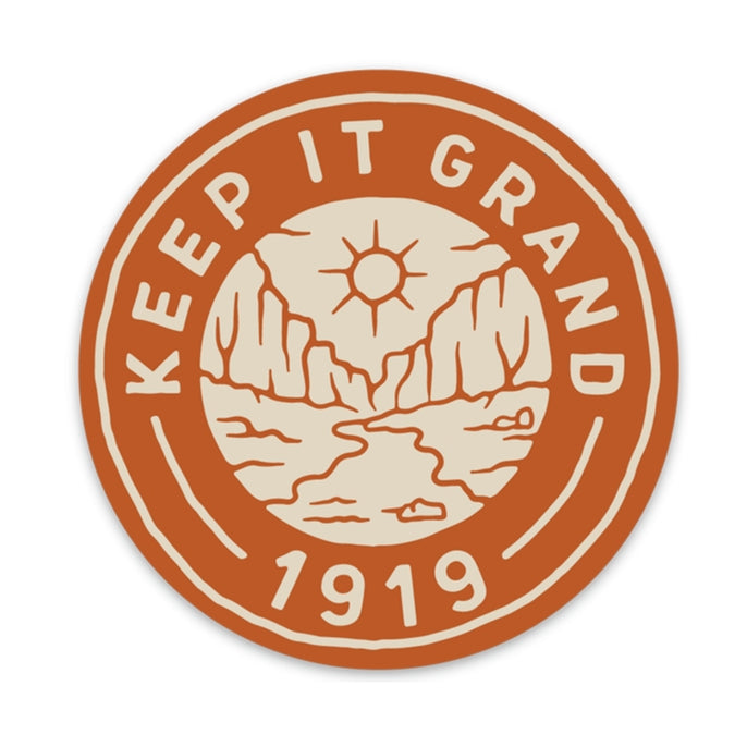 Round orange Keep It Grand 1919 sticker with a desert canyon scene in cream