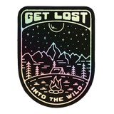 Holographic sticker labeled Get Lost Into the Wild featuring a mountain campsite under stars and a crescent moon