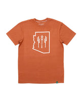 AZ Wilderness Tee in Redwood orange laid flat with white line art of the Arizona outline and three cactus silhouettes