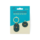 Matching keyring and dog tag set on teal packaging with two enamel charms