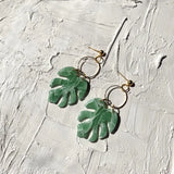 Green monstera leaf drop earrings with gold hoops