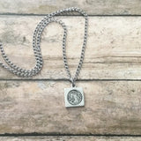 Full Moon Necklace with square pendant showing a textured moon image on a silver chain