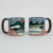 ceramic mug with artistic mountain designs on a white background
