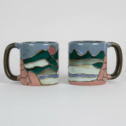 ceramic mug with artistic mountain designs on a white background
