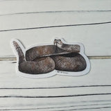 Rattlesnake sticker depicting a coiled brown snake with detailed scale pattern.