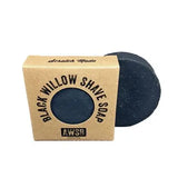 Black Willow Shave Soap in kraft packaging with a circular dark soap beside it.