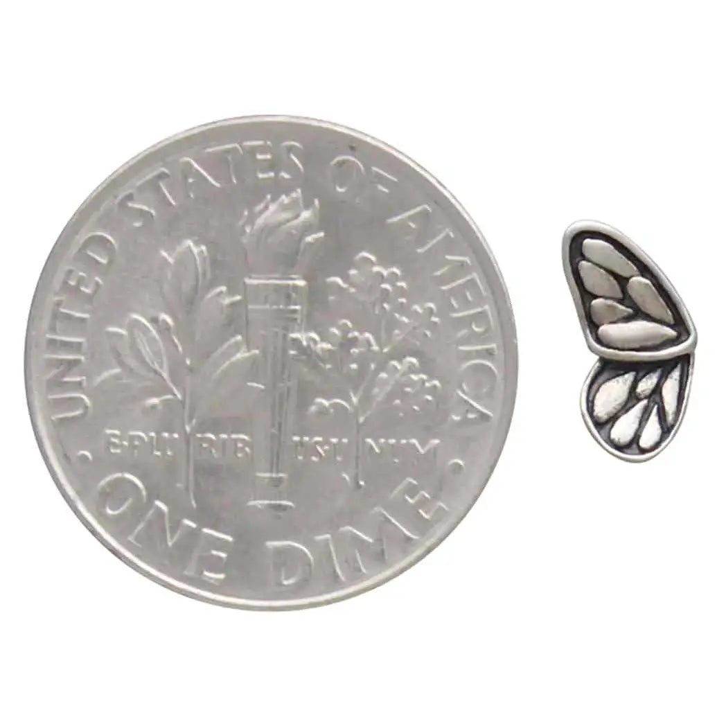 Butterfly wing stud earring shown beside a dime for scale.