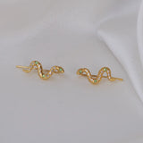 Pair of gold tone snake earrings encrusted with green and clear crystals.