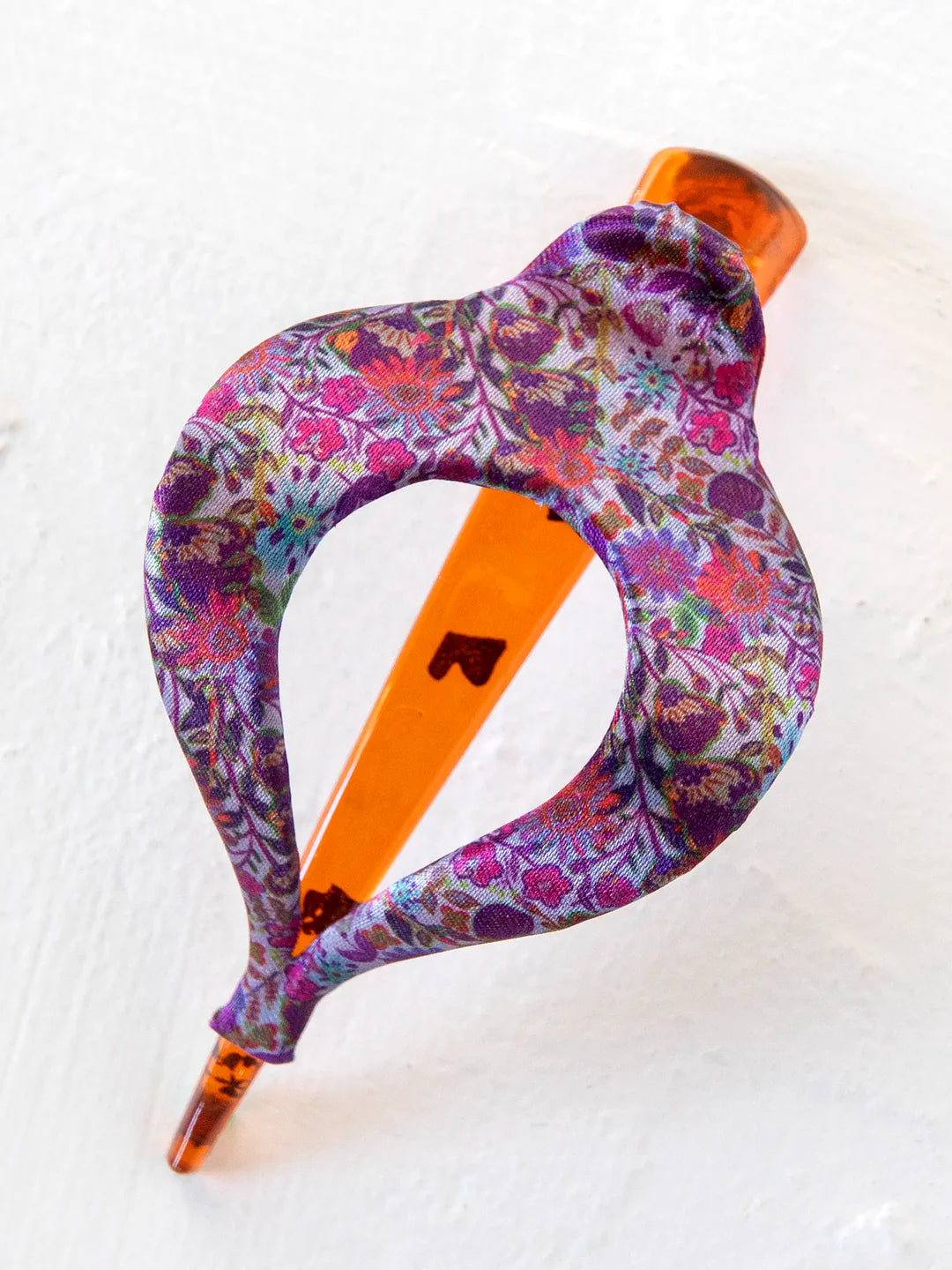 Close-up of a floral print Boho Clip wrapped around an orange base