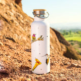 White water bottle decorated with hummingbirds and dots in a rocky desert setting.