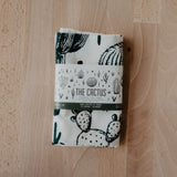 Folded cactus print tea towel with a monochrome desert illustration on natural fabric