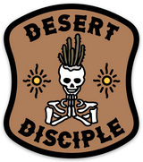 Desert Disciple sticker featuring a skeleton with cactus hair praying between two suns on a brown badge