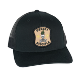 Desert Disciple patch on black trucker cap with mesh back