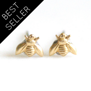 Gold bee stud earrings on a white background