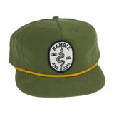 Ramble and Roam rope unstructured hat in olive green with a circular embroidered patch featuring a snake and a yellow rope trim.