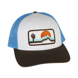 The Retrozona Trucker cap white front panel blue mesh with a desert patch showing cactus mountains and orange sun